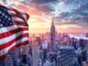 American flag billowing over New York City skyline at sunset, with tall skyscrapers and a colorful sky in the background.